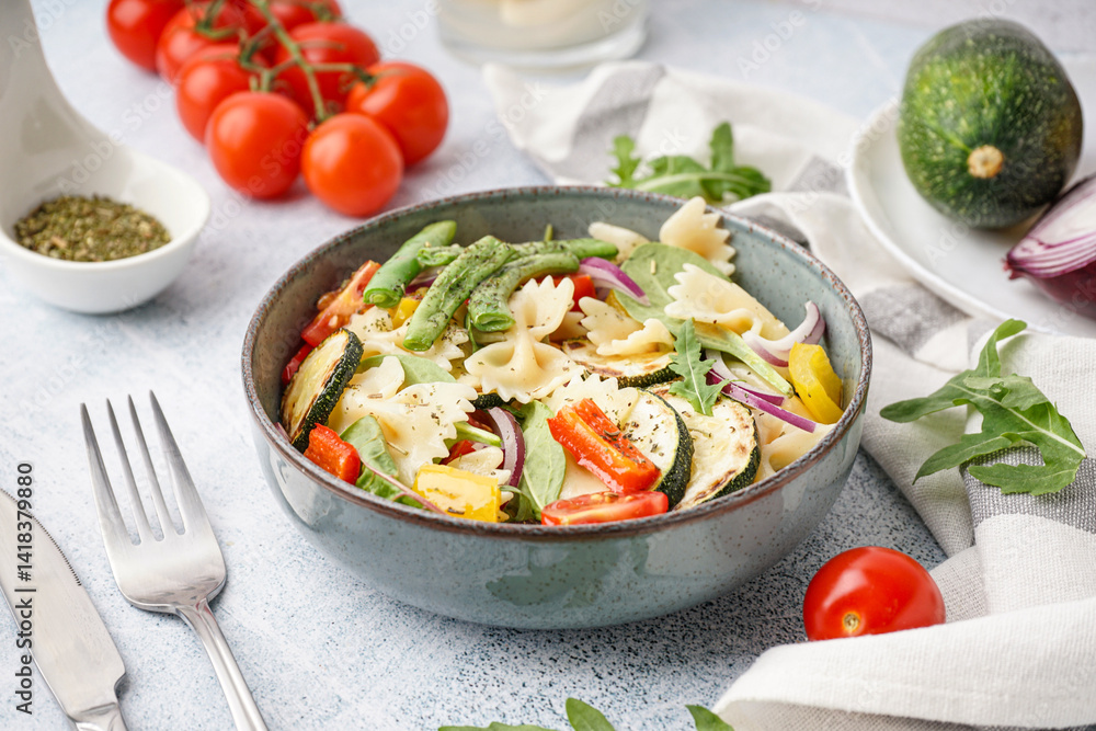 Bowl of tasty pasta salad with pepper and tomatoes on white background Bowl of tasty pasta salad with pepper and tomatoes on white background