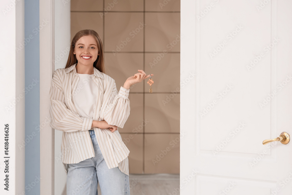 Beautiful young woman with keys standing in open doorway at home Beautiful young woman with keys standing in open doorway at home