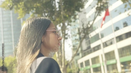 Native American woman with Hispanic features and Chilean descent, holding a mug, walking across a busy city street in a corporate district on a sunny day, with a determined stride and a slight smile