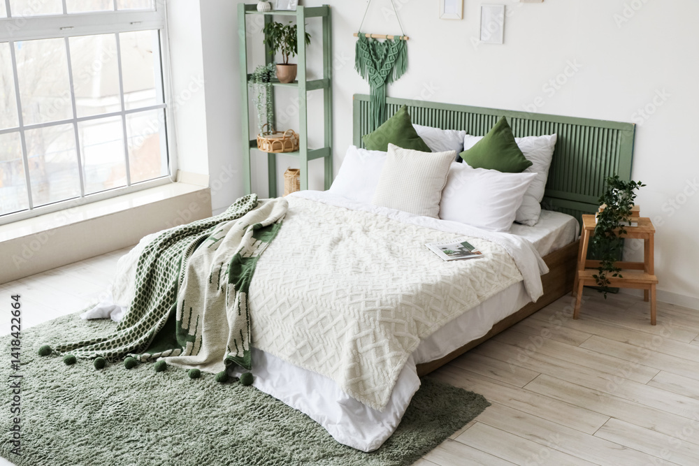 Modern bed with green plaid and shelving unit in interior of bedroom