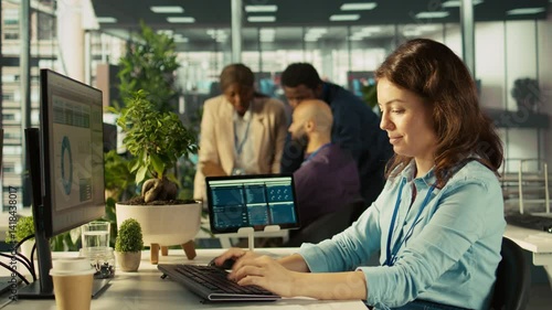 Employee at office desk typing on keyboard, editing documents on computer. Worker inputting data on spreadsheets in workplace at PC, working on statistical information, camera B