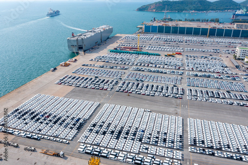 Aerial view of the huge ro-ro ship loading new cars. Automotive container carriers oversea services. Transportation business for prefabricated cars by sea freight 