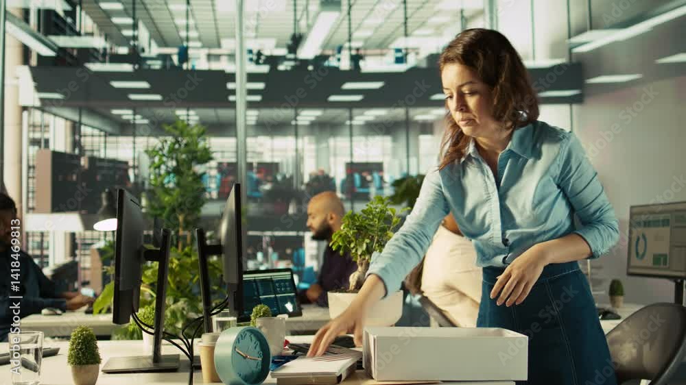 Employee getting consoled by colleagues after being fired, leaving office. Worker holding box filled with desk plants saying goodbye to coworkers after being laid off, camera B Employee getting consoled by colleagues after being fired, leaving office. Worker holding box filled with desk plants saying goodbye to coworkers after being laid off, camera B