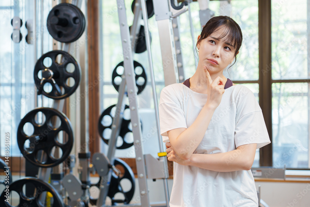 スポーツジムで考え事をする女性