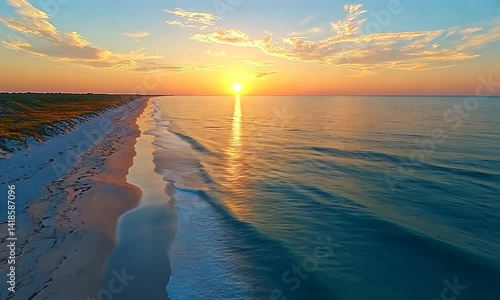 Sunrise over tranquil beach and ocean.