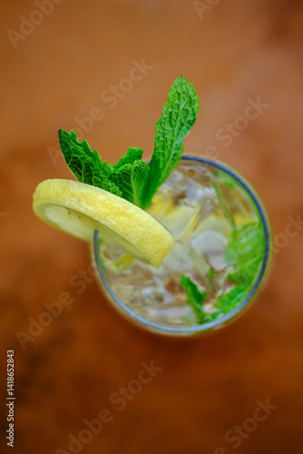 Close up overhead view of a cocktail or mocktail with ice, lemon and mint