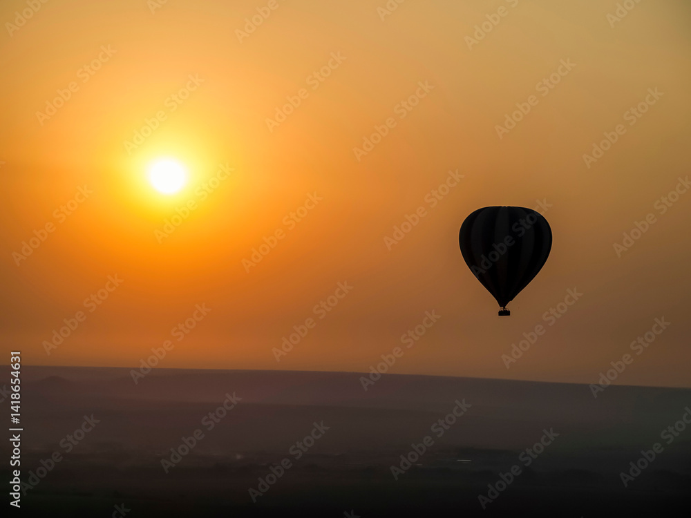 Hot Air Balloon Silhouette Against a Fiery African Sunset. Maasai Mara, Kenia, Africa. Hot Air Balloon Silhouette Against a Fiery African Sunset. Maasai Mara, Kenia, Africa.