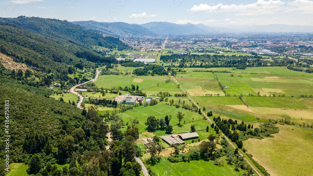 Fototapeta premium Aerial View of Lush Green Fields and Mountains Surrounding Northern Bogotá, Colombia