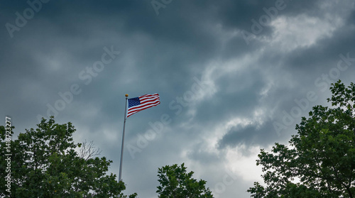 american flag waving in the wind of the storm sky