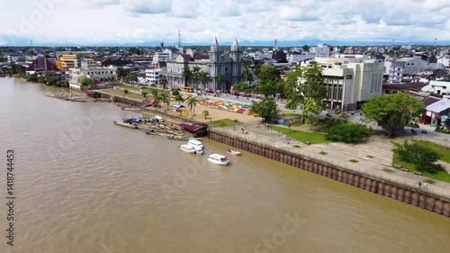 Aerial Majesty of Quibdó: River, Faith, and Rainforest. Drone views of Quibdó, Choco, Colombia, featuring the Atrato River, boats, rainforest, and the iconic cathedral. A vibrant mix of nature.