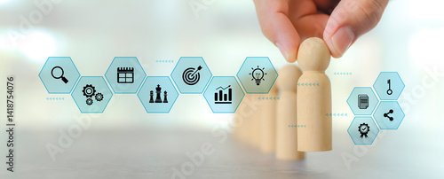 Hand chooses wooden person stands with HR human resources icons for personal leader training skill or leadership and challenge business team player and organization management teamwork
