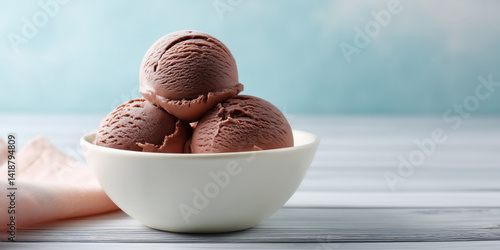 Obraz na płótnie Three scoops of chocolate ice cream in a white bowl on a wooden table with a light blue background. w salonie