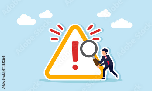 Businessman holding a magnifying glass next to an exclamation mark with a splash effect, illustration of the need for special attention to risky matters
