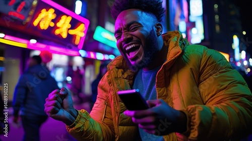Joyful man laughs using phone in vibrant neon-lit Asian city street at night