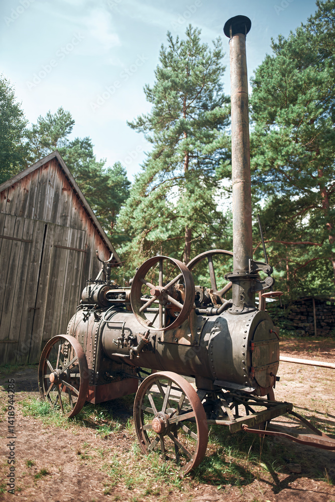 Antique mechanical engine with metal wheels outside
