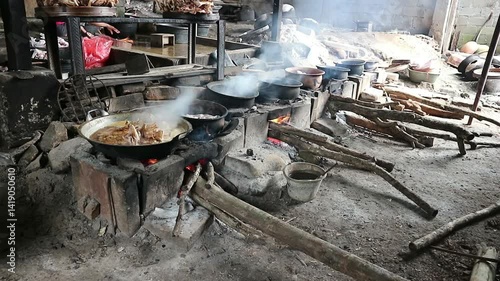 The process of roasting whole chicken meat by roasting it on a wood stove in a traditional and simple way, the meat is skewered with bamboo so that it roasts evenly.
