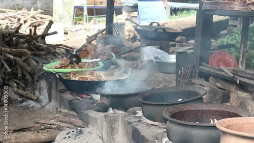 The process of roasting whole chicken meat by roasting it on a wood stove in a traditional and simple way, the meat is skewered with bamboo so that it roasts evenly.
