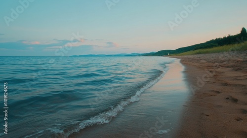 Sandy beach, calm water, evening sky, distant land.