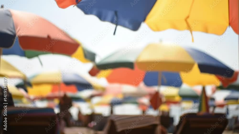 A Colorful Array of Beach Umbrellas Topping a Sunlit Sandy Shoreline with Lounge Chairs Ready for Relaxation on a Warm Summer Day