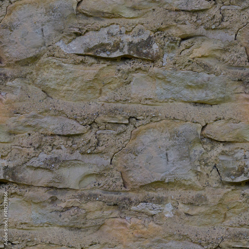 An old, gray wall made of stone and cement. Grey, stone background. Ancient ruins.  Stone texture.