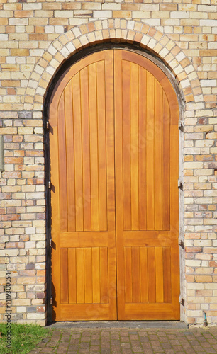 Arched double doors on a brick wall.