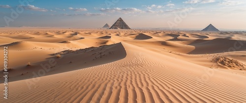 Windswept desert dunes with distant pyramids wide angle panoramic view horizontal symmetric background.
