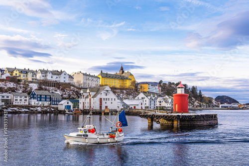 Blick auf die Stadt Ålesund mit Molenturm und Fischerboot in Norwegen