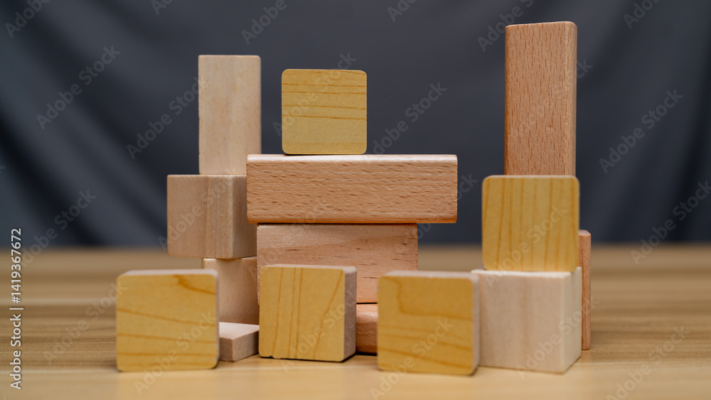 Obraz premium A creative arrangement of wooden blocks of various shapes and sizes, showcasing natural wood textures and colors. Perfect for educational, architectural, or design concepts.
