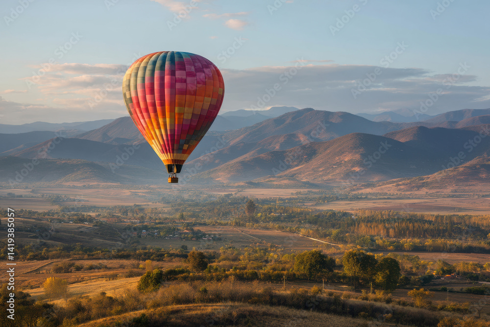Fototapeta premium Hot air balloon gently floats over scenic landscape, creating sense of wonder and amazement as it ascends toward sky, an inspiring journey
