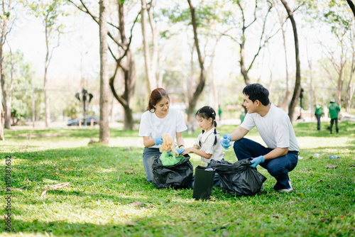 Asian parents and child collect bottles at the park, sharing love, teamwork, and care. A green lifestyle moment promoting recycling, unity