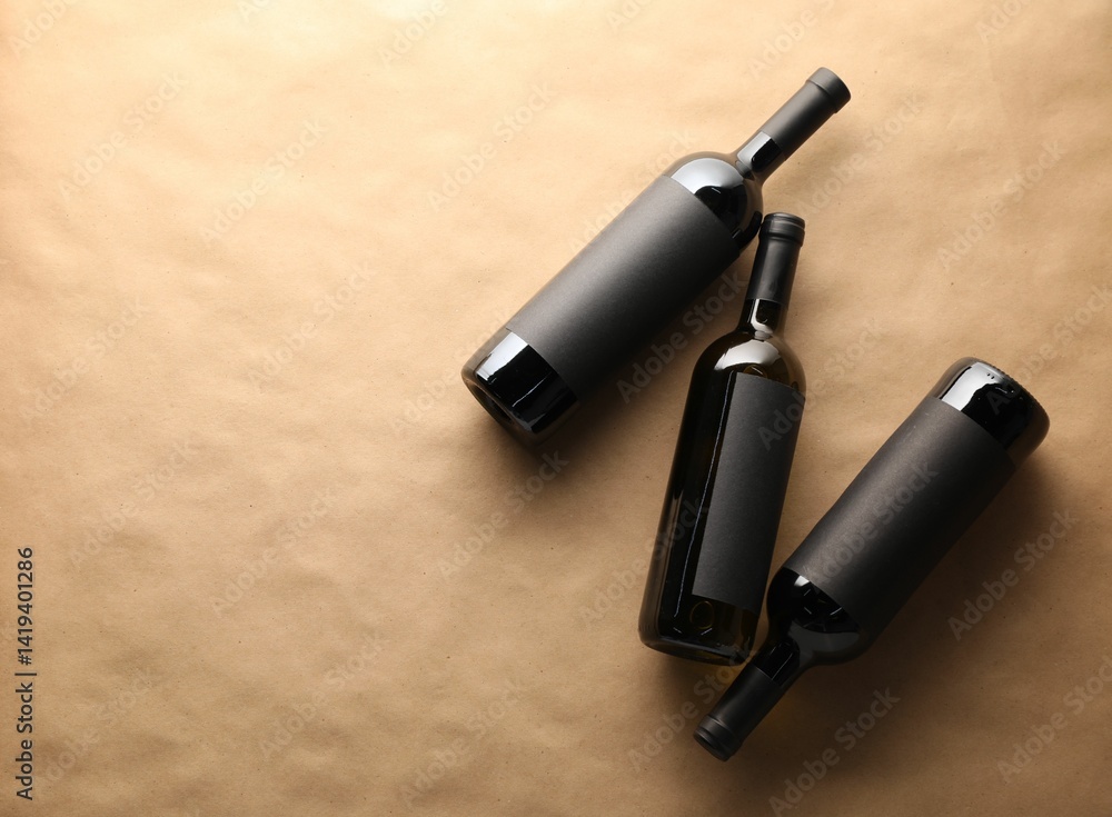 Bottles of wine on parchment paper, flat lay. Space for text Bottles of wine on parchment paper, flat lay. Space for text