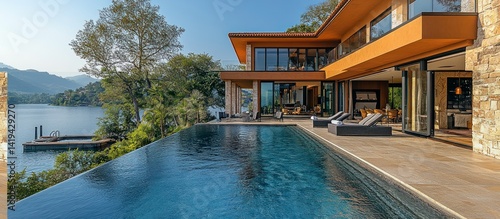 Luxurious infinity pool overlooking lake with modern villa