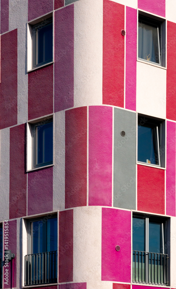 Colorful facade of modern residential building showing windows and balconies