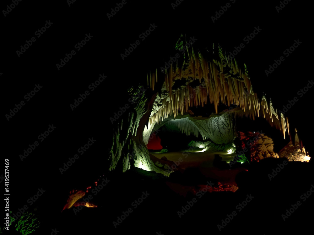A cave with a light shining on it. The cave is dark and the light is illuminating the cave