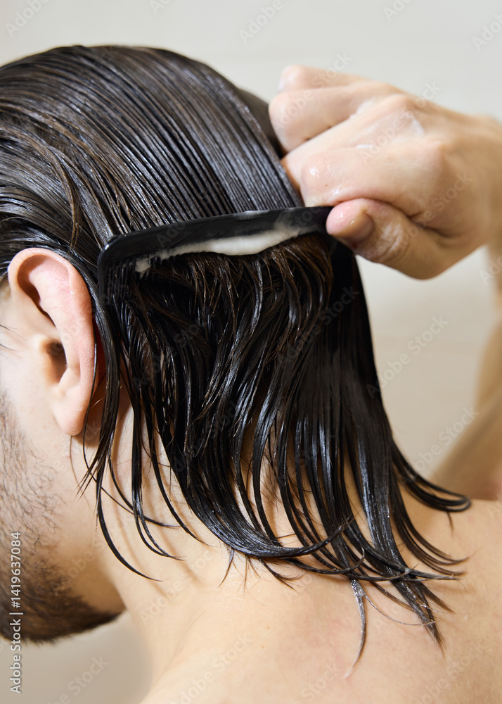 Obraz premium a brunette with long hair applies hair balm, caring for them