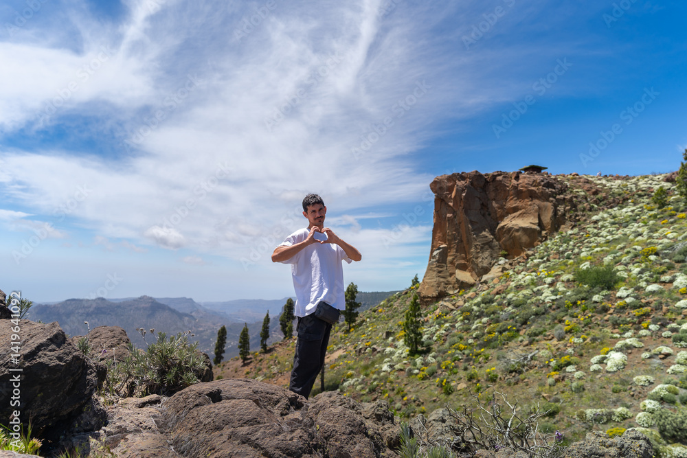 Naklejka premium Young man hiking at the top of Gran Canaria Island in a sunny day. Canary islands. Spain