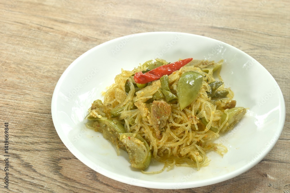 stir fried spicy mixed glass noodles with vegetables and pork belly in Curry powder Thai northern style on plate stir fried spicy mixed glass noodles with vegetables and pork belly in Curry powder Thai northern style on plate