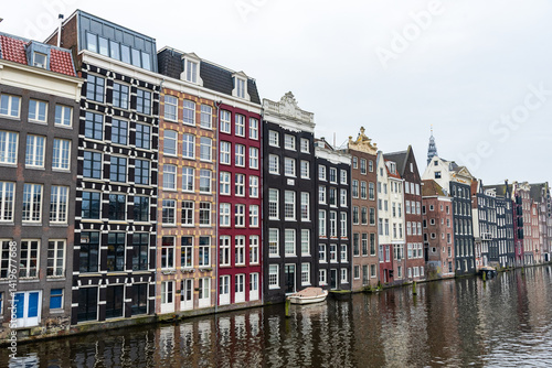 Obraz na płótnie Traditional colorful dutch houses reflecting on amsterdam canal under cloudy sky. House apartments w salonie
