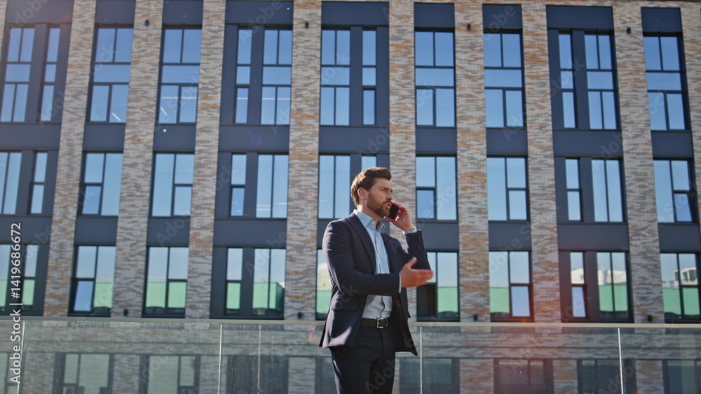 Angry man quarrelling cellphone walking downtown. Nervous businessman shouting