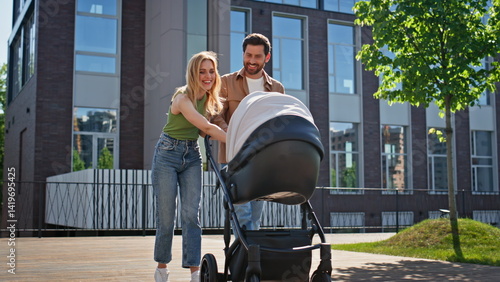Foto Delighted couple strolling newborn walking with infant at modern life complex