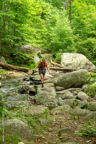 Obraz na płótnie Woman Steps Over Large Boulders to Cross Creek in Shenandoah w salonie