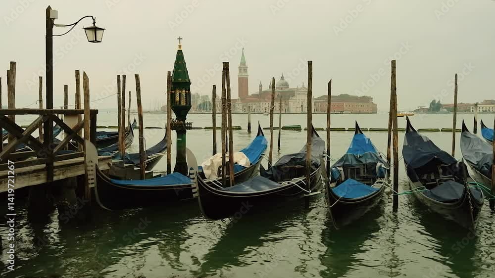 Gondolas moored near San Marco square with a view at San Giorgio Maggiore Church at the background. Misty morning in Venice, Italy. Gondolas moored near San Marco square with a view at San Giorgio Maggiore Church at the background. Misty morning in Venice, Italy.