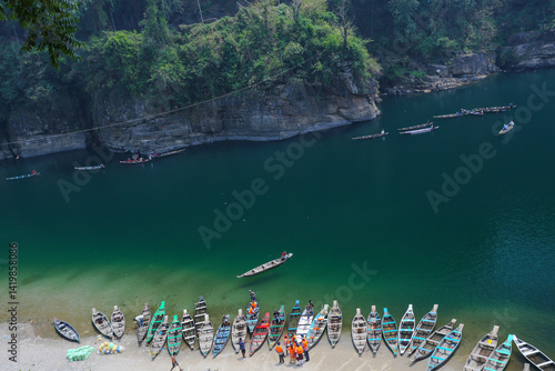 Wooden country boats waiting at the edge of the riverbank at Dawki (Maghalaya India). These boats offer ride to the tourists in the Umngot river which is said to be the cleanest river of India.