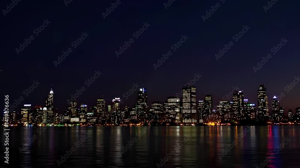 Urban skyline silhouette at dusk with calm waters reflecting colors Urban skyline silhouette at dusk with calm waters reflecting colors