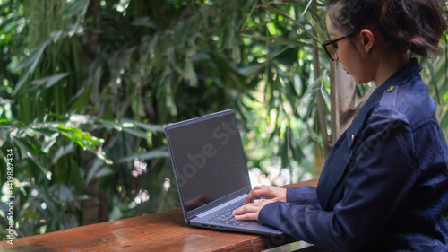 Wallpaper Mural Businesswoman working on laptop on rich tree background in cafe, freelancer girl with independent working time with comfortable working anywhere Torontodigital.ca