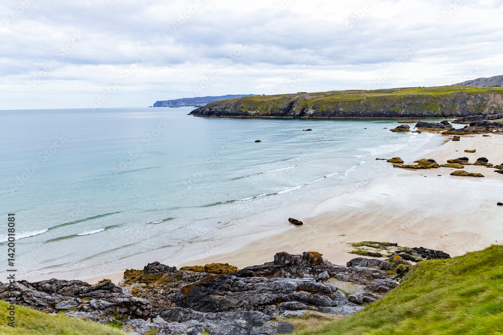 Obraz premium Panoramic viewpoint above Durness Beach, powerful waves crash against golden sand and striking rocks rise along the shore. A wild, breathtaking coastal scene in the heart of the Scottish Highlands.