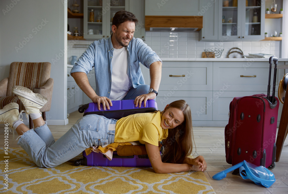 Funny comic shot with playful loving couple packing clothes for travel