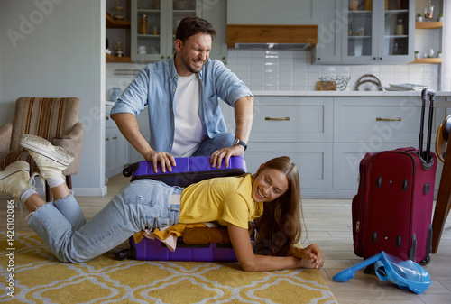 Obraz na płótnie Funny comic shot with playful loving couple packing clothes for travel w salonie