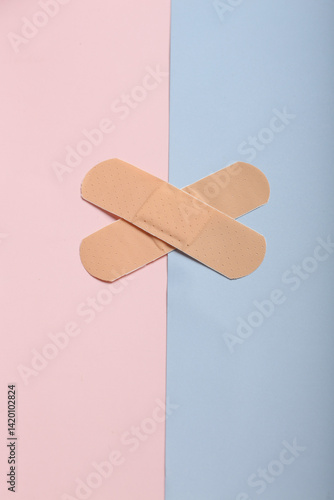Fotografie Adhesive bandage plaster on on a coloured background, the concept of protection