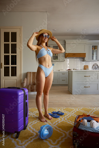 Obraz na płótnie Dreamy woman tourist wearing swimwear standing at travel suitcases w salonie